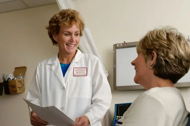 A clinician talking with a visitor while reviewing documents