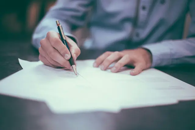 Hands writing a medical case summary on paper