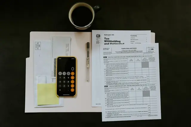 Hands reviewing a cost document beside a calculator