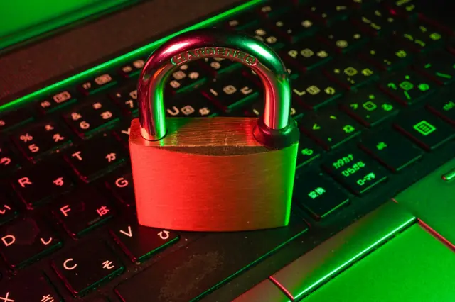 A closed padlock over a keyboard, representing information security